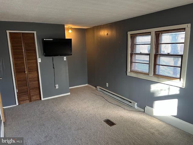 unfurnished bedroom featuring carpet, a closet, and baseboard heating