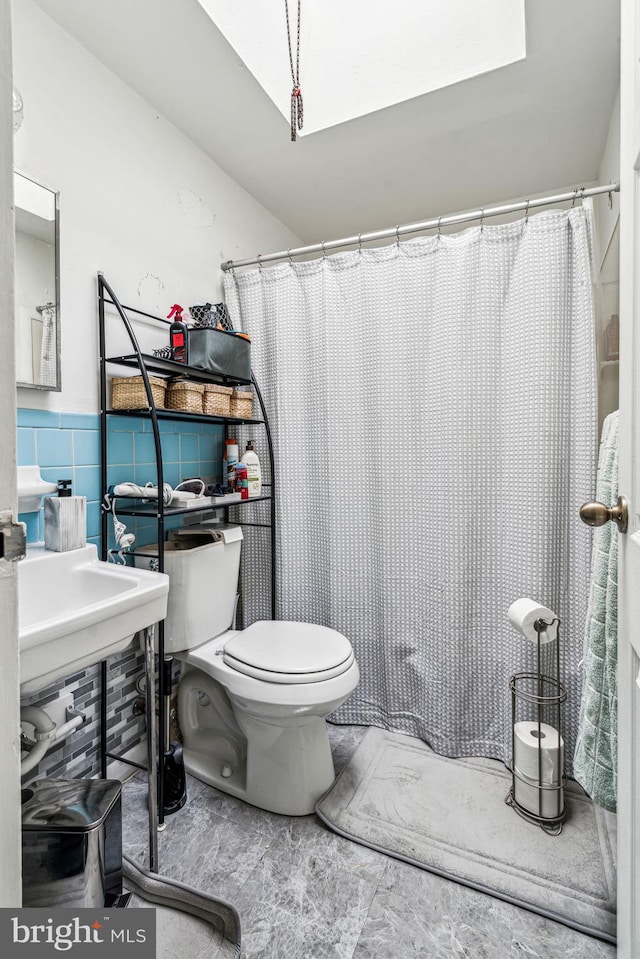 bathroom featuring a shower with curtain, toilet, and tile walls