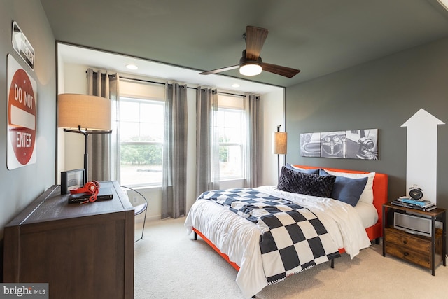 carpeted bedroom featuring multiple windows and ceiling fan