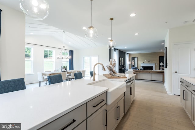 kitchen with gray cabinets, sink, a healthy amount of sunlight, and decorative light fixtures