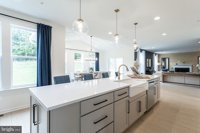 kitchen with a center island with sink, a healthy amount of sunlight, stainless steel dishwasher, and sink