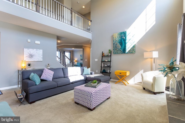 living room featuring carpet flooring, crown molding, and a high ceiling