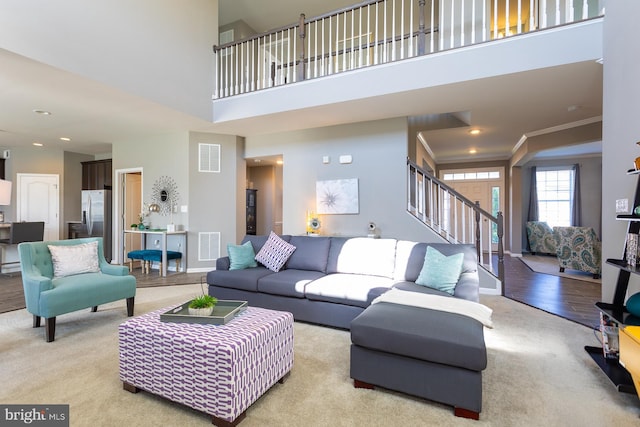 carpeted living room featuring ornamental molding and a high ceiling