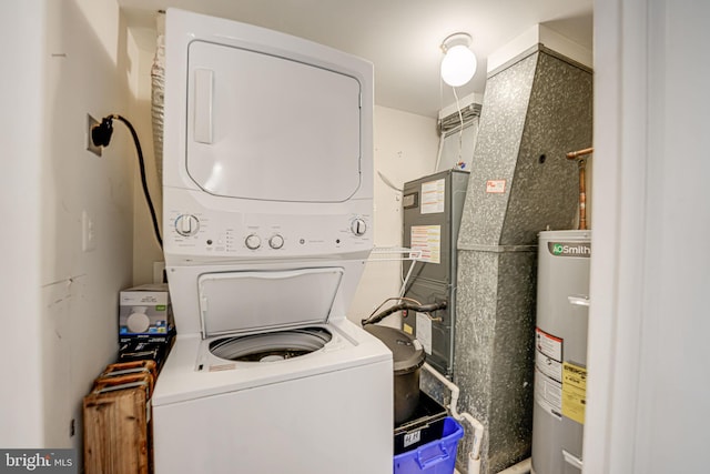 laundry area with electric water heater and stacked washer / dryer