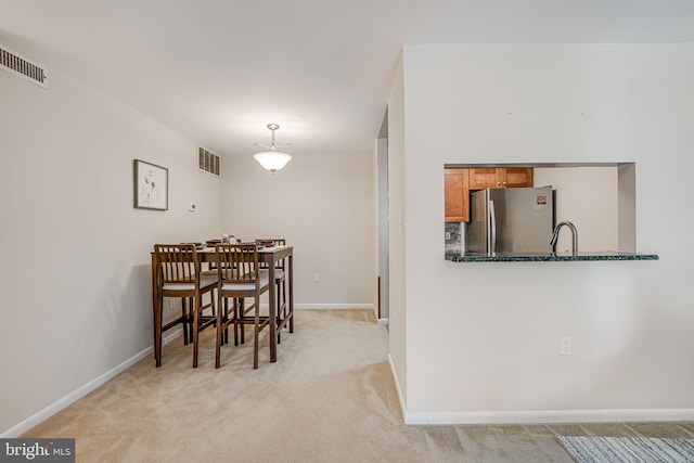 carpeted dining room with sink