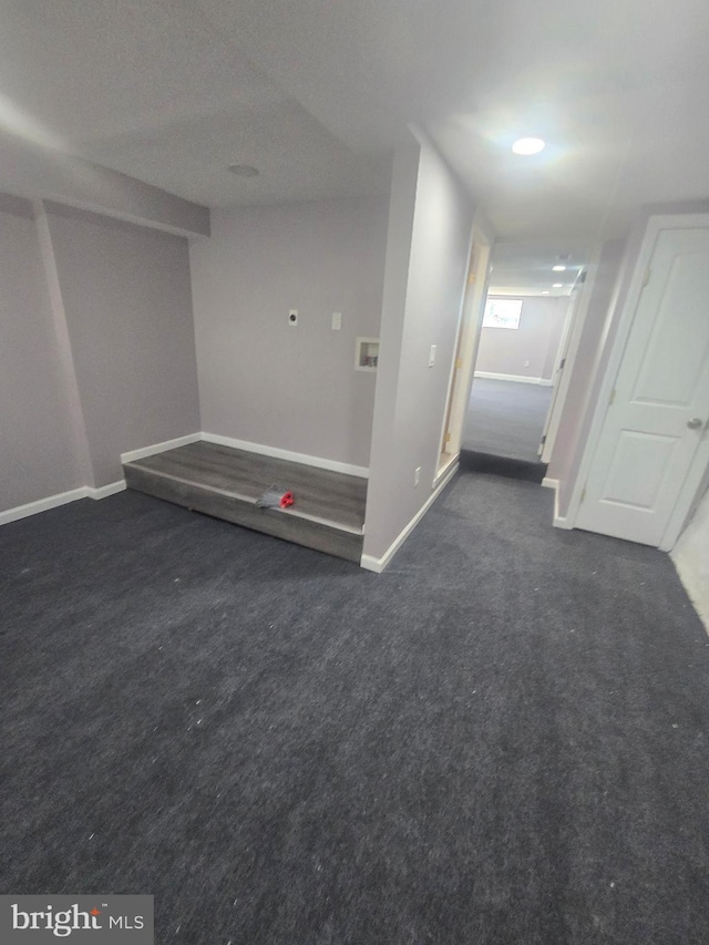 unfurnished room featuring dark carpet