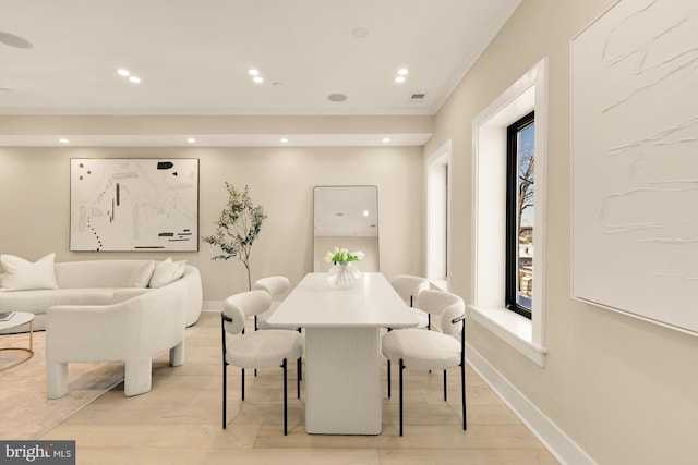 dining space featuring light hardwood / wood-style floors and ornamental molding