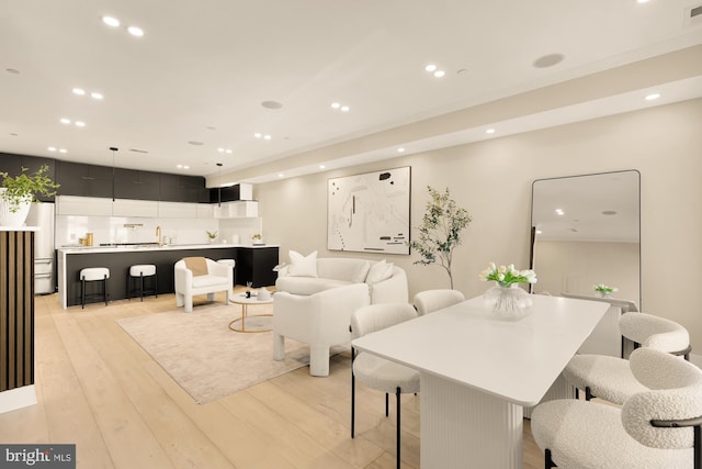 dining area with sink and light hardwood / wood-style floors