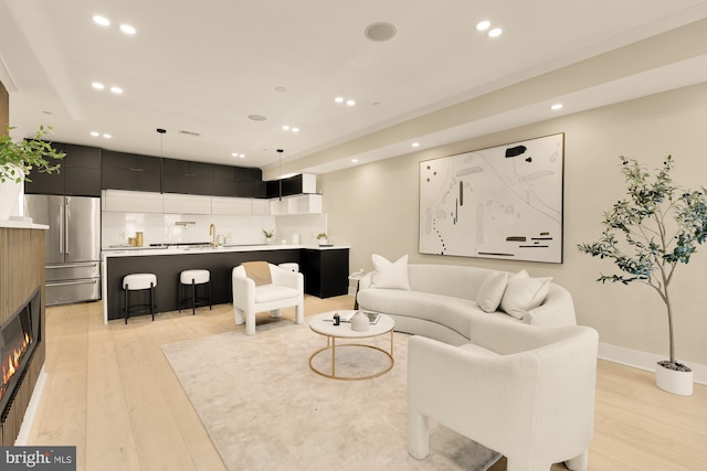 living room with light hardwood / wood-style flooring and sink