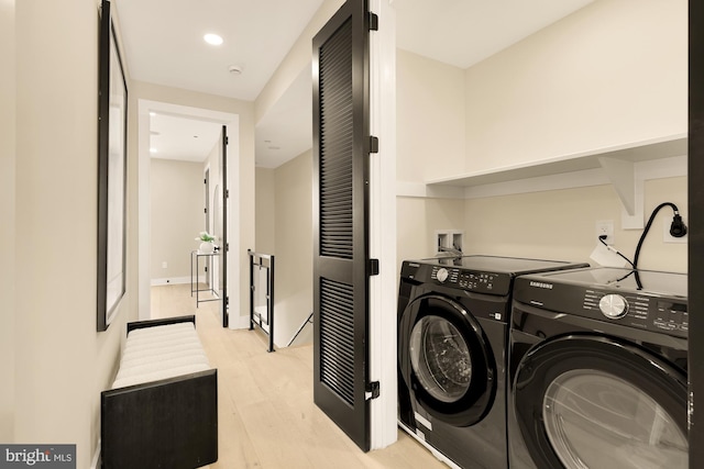 washroom with light wood-type flooring and separate washer and dryer