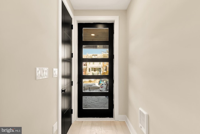 doorway with light wood-type flooring