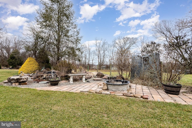 view of yard featuring a fire pit and a patio