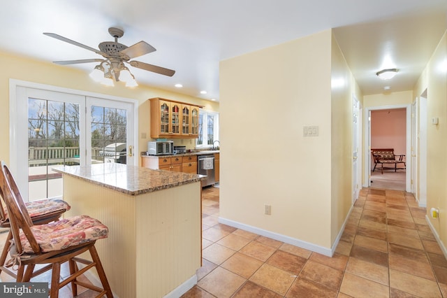 4229 Roundtop Rd, Elizabethtown, PA 17022 - kitchen featuring stainless steel dishwasher, a center island, glass insert cabinets, a ceiling fan, and stone counters