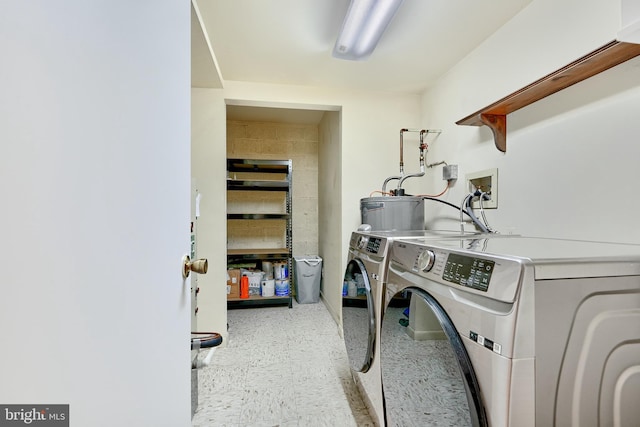 washroom featuring electric water heater and separate washer and dryer