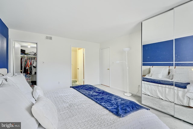 bedroom with a walk in closet and carpet floors