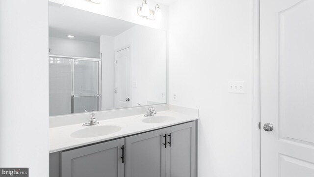 bathroom with vanity and a shower with door