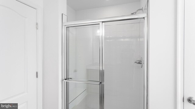 bathroom featuring a shower with shower door