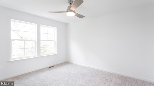 empty room with ceiling fan, carpet, and a healthy amount of sunlight