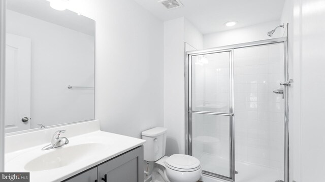 bathroom with vanity, toilet, and an enclosed shower