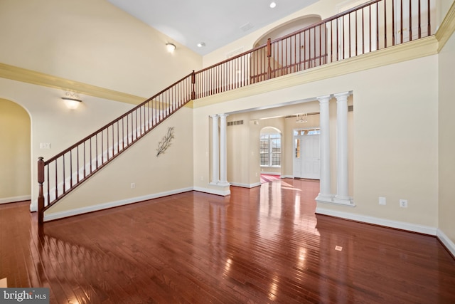 unfurnished living room with a high ceiling and hardwood / wood-style flooring