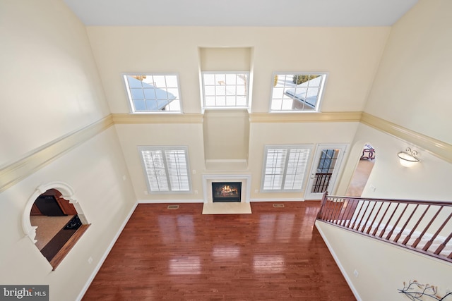 living room with dark hardwood / wood-style flooring and a towering ceiling