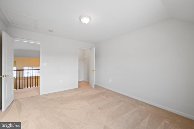 unfurnished bedroom with light colored carpet, vaulted ceiling, and a closet