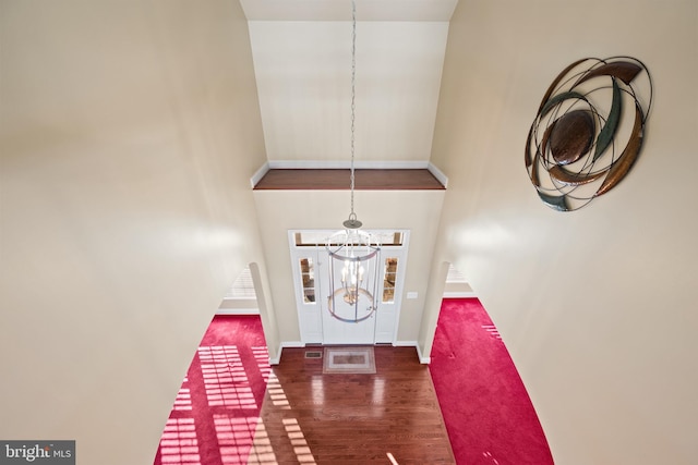 entryway featuring a towering ceiling, a chandelier, and dark hardwood / wood-style floors