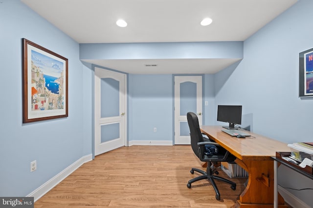 home office with light hardwood / wood-style floors