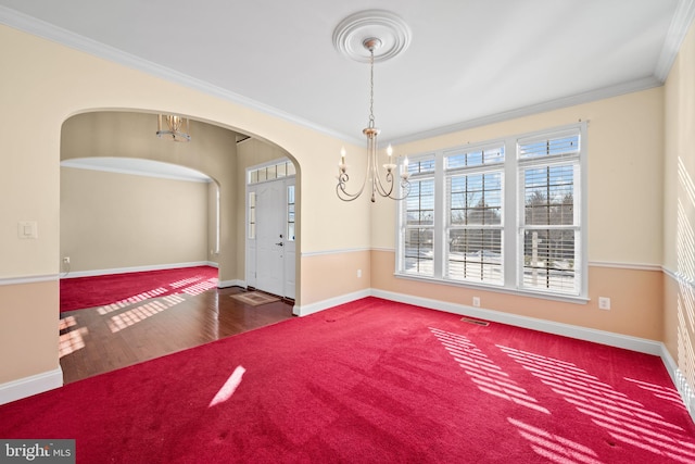 empty room with carpet flooring, a notable chandelier, and ornamental molding