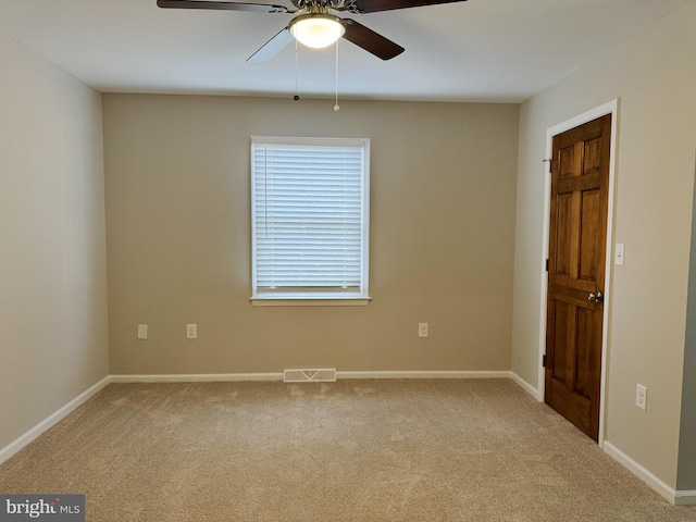 carpeted spare room with ceiling fan