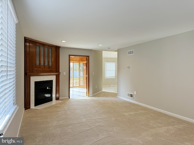 unfurnished living room featuring light carpet