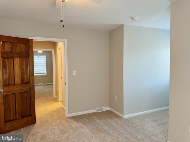 spare room with light carpet and ceiling fan