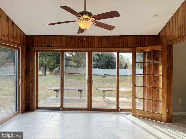 entryway featuring ceiling fan, wood walls, light tile patterned floors, and french doors