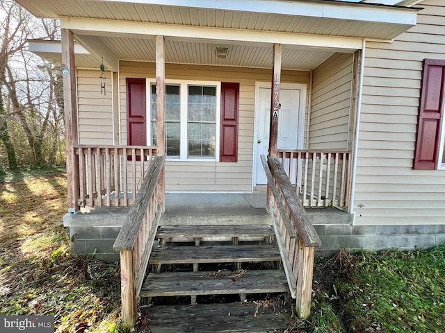 view of exterior entry featuring covered porch