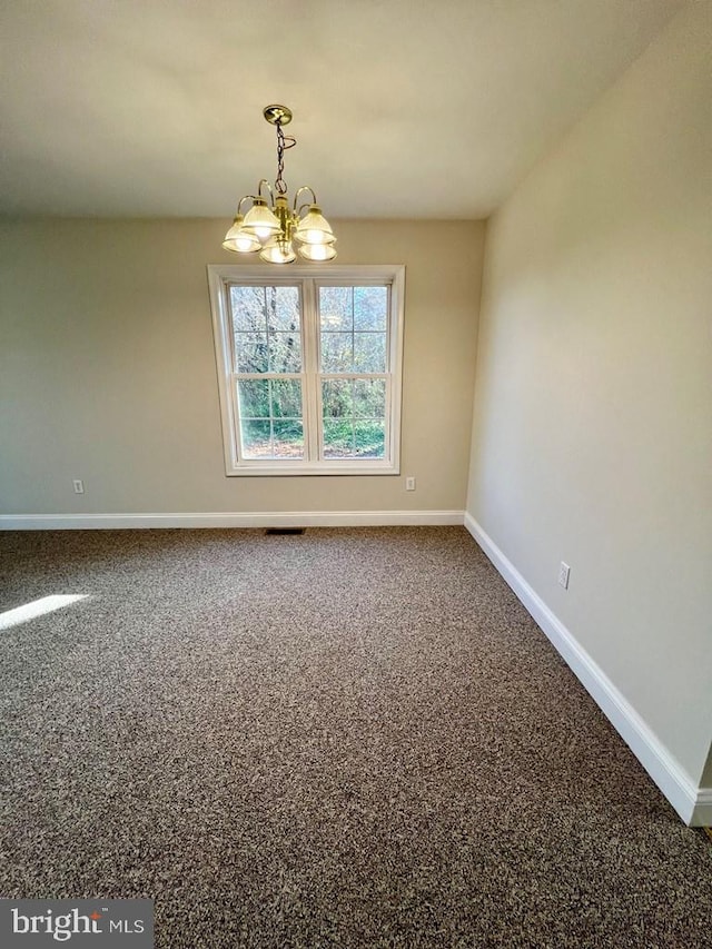 unfurnished room featuring carpet and a notable chandelier