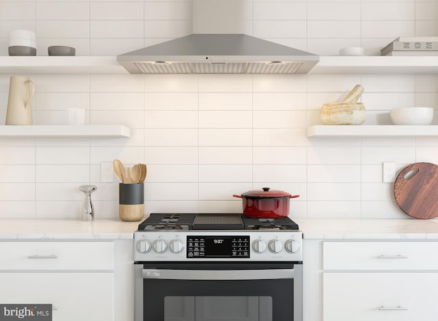 kitchen featuring white cabinetry, light stone countertops, tasteful backsplash, stainless steel range oven, and island range hood