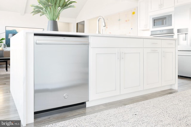 kitchen with white cabinetry, sink, vaulted ceiling with beams, white appliances, and light wood-type flooring