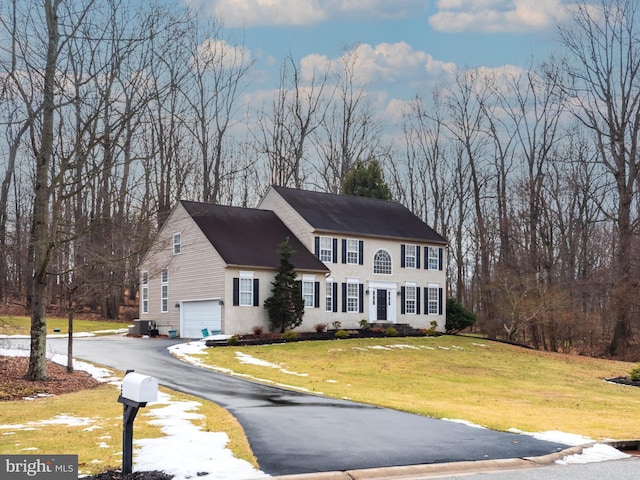 colonial home with a garage and a front lawn