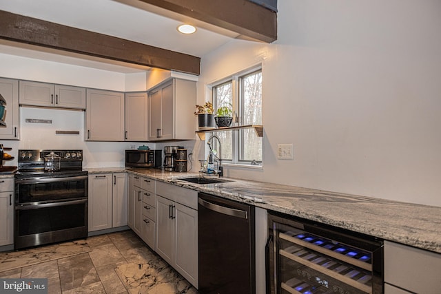 kitchen featuring appliances with stainless steel finishes, light stone counters, beverage cooler, sink, and gray cabinets