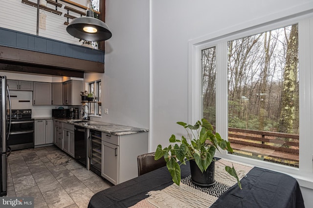 kitchen with sink, gray cabinets, light stone counters, and black appliances