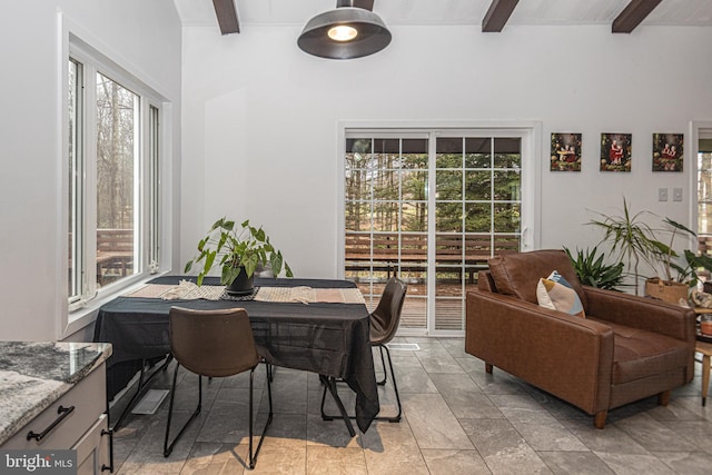 dining area featuring beam ceiling and a healthy amount of sunlight