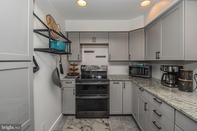 kitchen with gray cabinets, light stone countertops, and stainless steel appliances