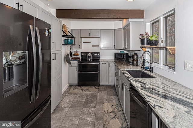 kitchen with beamed ceiling, sink, a wealth of natural light, and black appliances