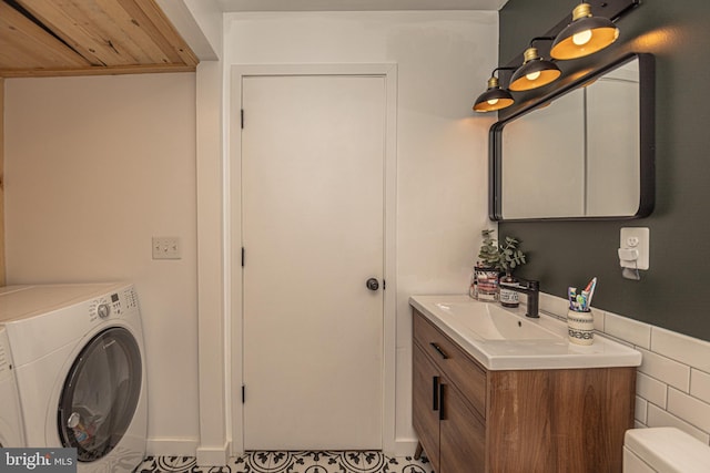 bathroom featuring tile patterned flooring, washer / dryer, vanity, and toilet