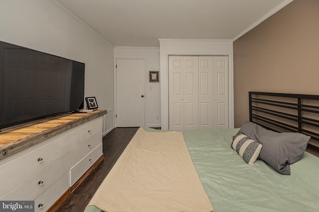 bedroom with dark hardwood / wood-style flooring, ornamental molding, and a closet