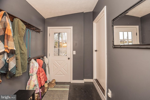 entryway with a textured ceiling and lofted ceiling