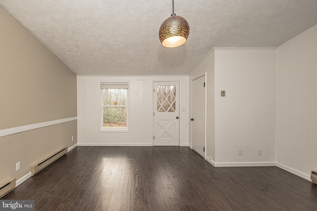 empty room with a textured ceiling, dark wood-type flooring, and a baseboard heating unit