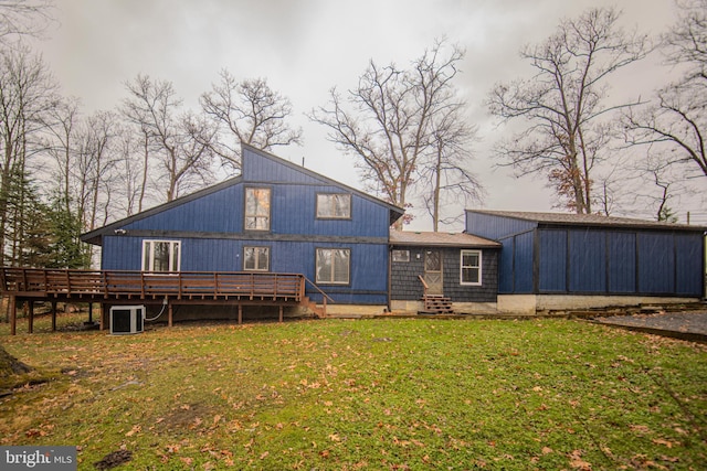 rear view of property with a lawn, central air condition unit, and a deck