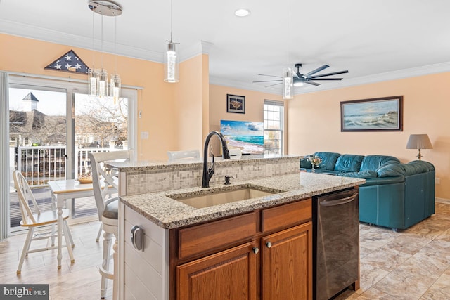 kitchen with pendant lighting, a kitchen island with sink, ornamental molding, and sink