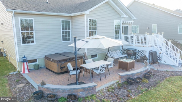 rear view of property featuring a patio, a hot tub, an outdoor fire pit, and a wooden deck